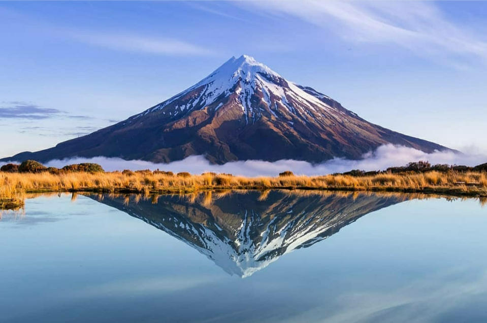 'Mount Taranaki, New Zealand' by @superthijs shows Mount Taranaki  in New Zeland reflected in a lake.