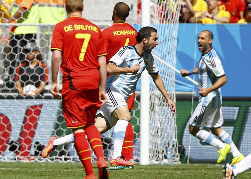 Argentina's Gonzalo Higuain runs past Belgium's Kevin De Bruyne (7) and Vincent Kompany to celebrate after scoring a goal during their 2014 World Cup quarter-finals at the Brasilia national stadium in Brasilia July 5, 2014. REUTERS/Damir Sagolj