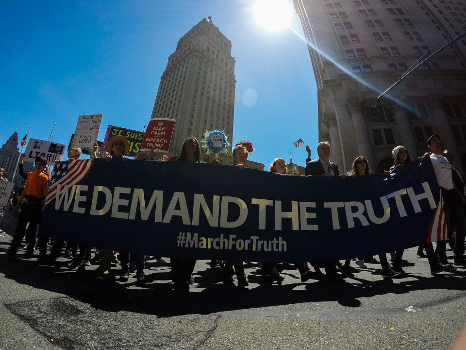 New York City protesters march holding a banner