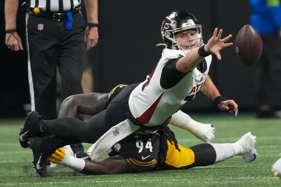 Atlanta Falcons quarterback Logan Woodside tosses the ball as he gets is tackled by Pittsburgh Steelers defensive tackle Armon Watts during the second half of a preseason NFL football game Thursday, Aug. 24, 2023, in Atlanta. (AP Photo/Gerald Herbert)