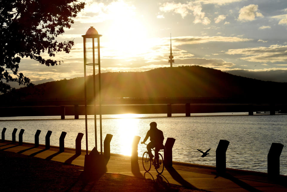 A cyclist is seen on the Lake Burley Griffin foreshore in Canberra.