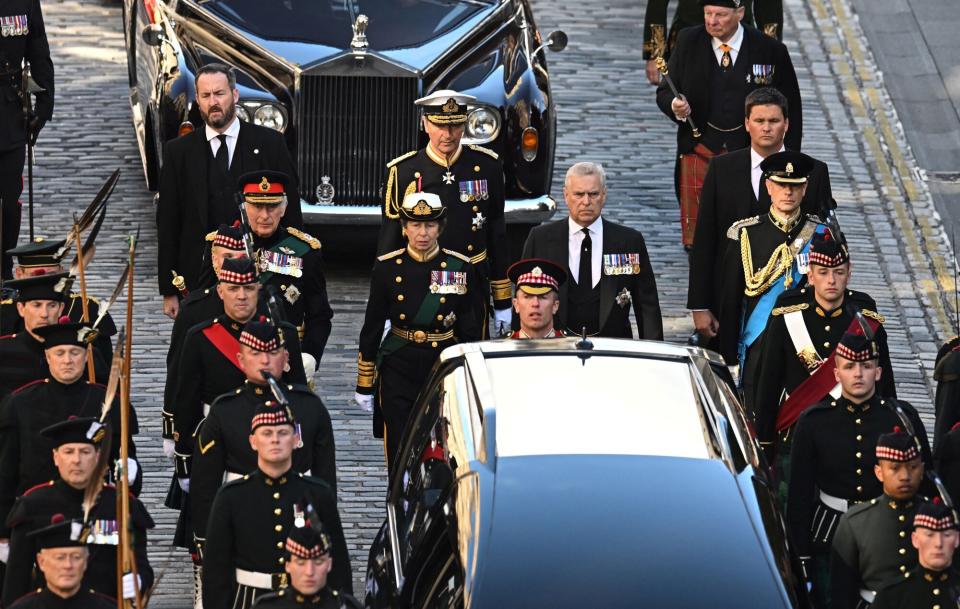 Britain's King Charles III flanked by Britain's Princess Anne, Princess Royal, Britain's Prince Andrew, Duke of York and Britain's Prince Edward, Earl of Wessex, walk behind the procession of Queen Elizabeth II's coffin, from the Palace of Holyroodhouse to St Giles Cathedral, on the Royal Mile on September 12, 2022, where Queen Elizabeth II will lie at rest. - Mourners will on Monday get the first opportunity to pay respects before the coffin of Queen Elizabeth II, as it lies in an Edinburgh cathedral where King Charles III will preside over a vigil.