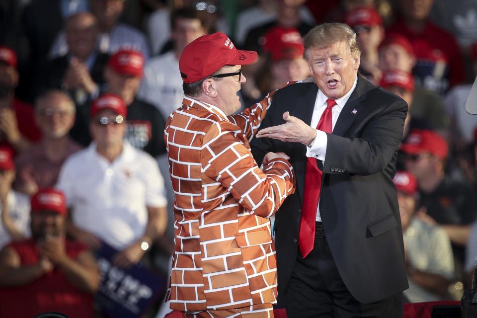 President Donald Trump calls up Blake Marnell, wearing a jacket with bricks representing a border wall, to the stage during a 'Make America Great Again' campaign rally at Williamsport Regional Airport on May 20 in Montoursville, Pa.