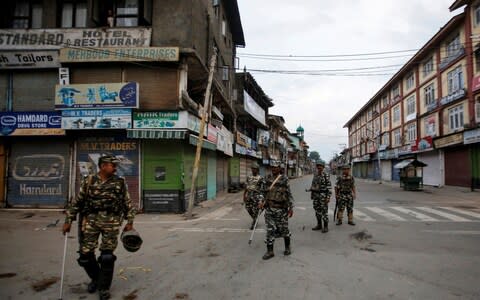 Indian security forces personnel patrol a deserted street during restrictions after the government scrapped special status for Kashmir - Credit: DANISH ISMAIL/&nbsp;REUTERS