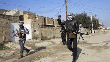 Gunmen fighters walk with their weapons in the streets of the city of Ramadi, 100 km (62 miles) west of Baghdad, in this January 21, 2014 file photo. REUTERS/Stringer/Files