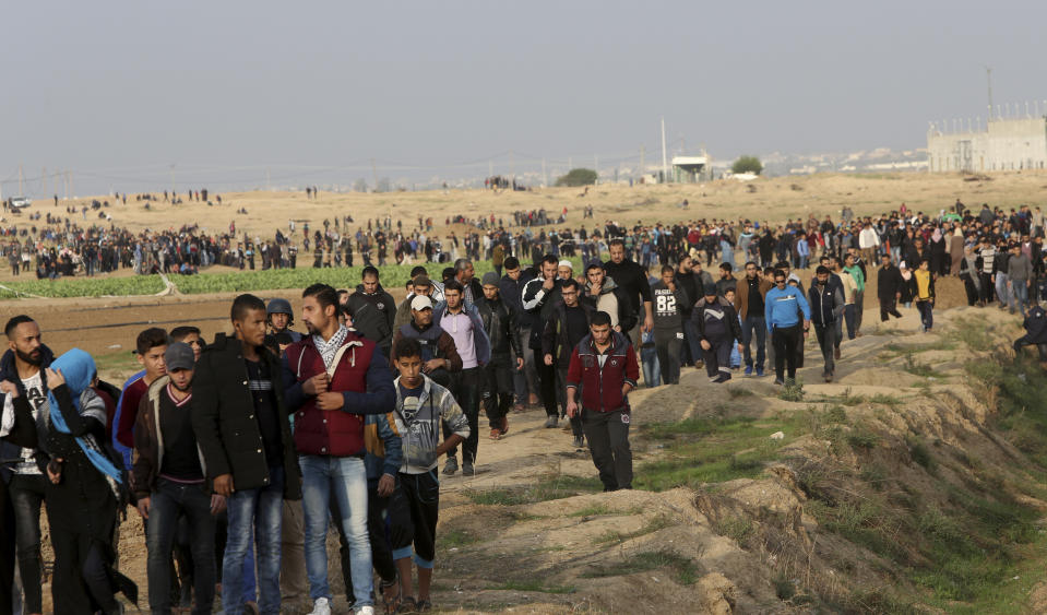 FILE- Protesters walk toward the fence of Gaza Strip border with Israel during a protest east of Gaza City, Friday, Nov. 16, 2018. Rights groups said Thursday. Dec. 2, 2021, that Israel failed to investigate shootings that killed more than 200 Palestinians and wounded thousands at violent protests along the Gaza frontier in recent years, strengthening the case for the International Criminal Court to intervene. (AP Photo/Adel Hana, File)