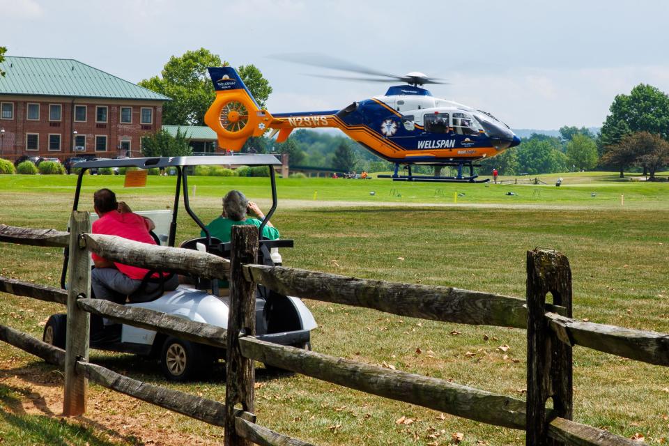 Golfers watch a medical helicopter take off on the golf course at the scene where a man was heavily entrapped inside a minivan after a crash on Route 30, Friday, Aug. 2, 2024, in Berwick Township.