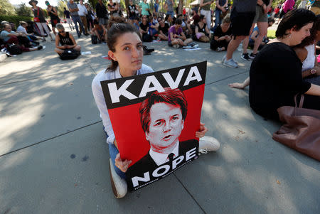 A demonstrator sits on the ground during a protest and rally in opposition to U.S. Supreme Court nominee Brett Kavanaugh in Washington, U.S., October 4, 2018. REUTERS/Kevin Lamarque