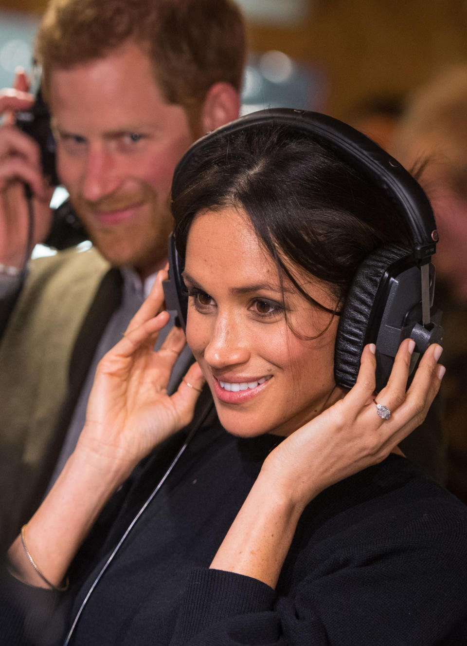 Britain's Prince Harry and his fiancée US actress Meghan Markle listen to a broadcast through headphones during a visit to Reprezent 107.3FM community radio station in Brixton, south west London on January 9, 2018.   / AFP PHOTO / POOL / Dominic Lipinski        (Photo credit should read DOMINIC LIPINSKI/AFP via Getty Images)