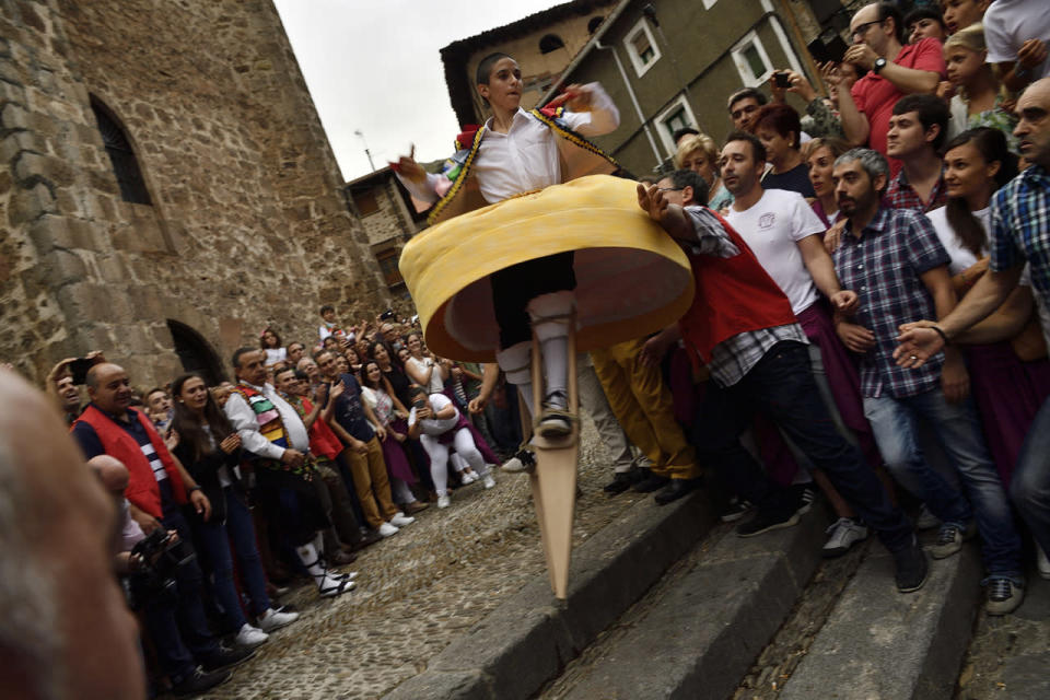 <p>People surround dancers as they perform on stilts in honor of Saint Mary Magdalene in a street for the traditional “Danza de Los Zancos” (Los Zancos Dance), in the small town of Anguiano, northern Spain, July 23, 2016. (AP Photo/Alvaro Barrientos)</p>