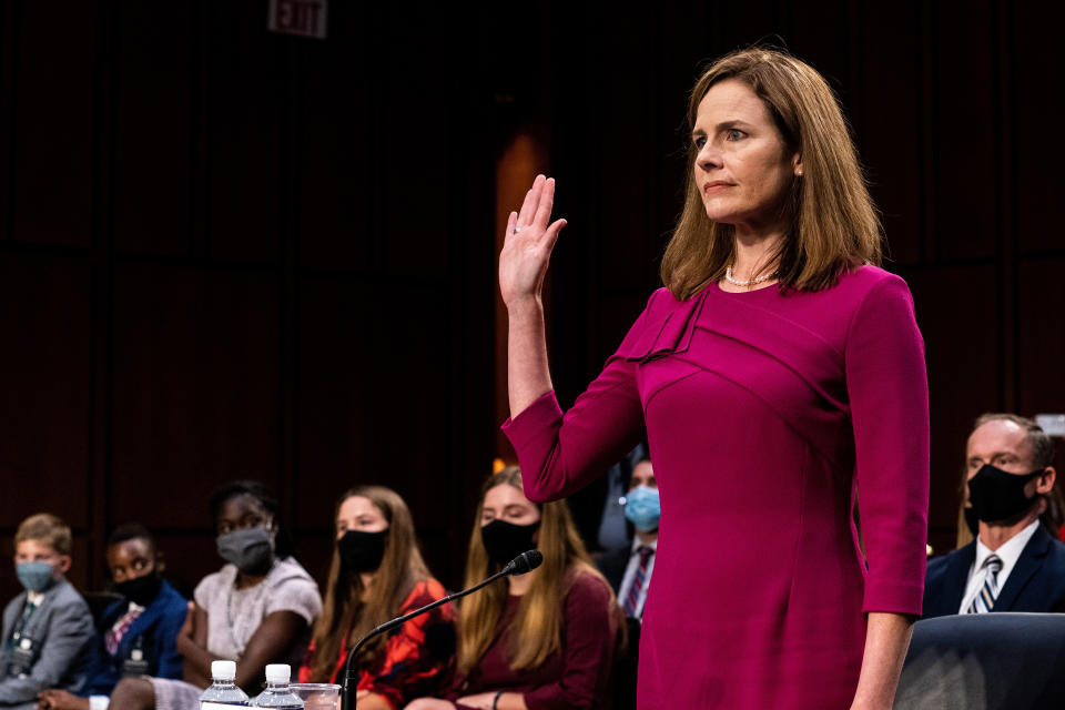 La jueza Amy Coney Barrett, con su familia detrás de ella, toma protesta para testificar ante la Comisión Judicial del Senado, en el primer día de su audiencia de confirmación en el Senado en Washington, el 12 de octubre de 2020. (Erin Schaff/The New York Times)