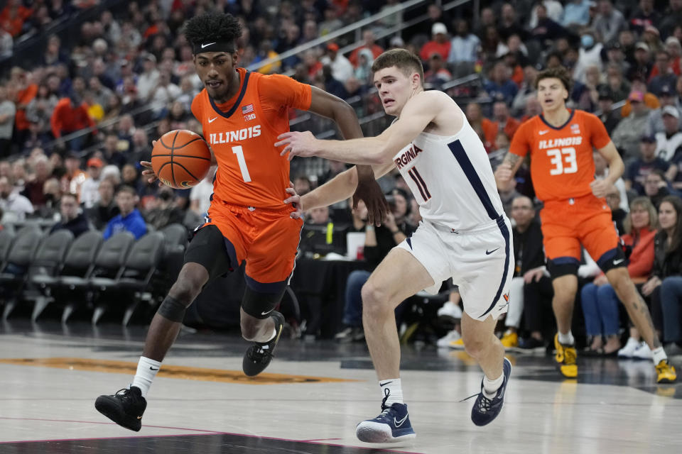 Illinois' Sencire Harris (1) drives around Virginia's Isaac McKneely (11) during the first half of an NCAA college basketball game Sunday, Nov. 20, 2022, in Las Vegas. (AP Photo/John Locher)