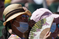 A spectator uses a fan to cool off at the U.S. Olympic Track and Field Trials Friday, June 25, 2021, in Eugene, Ore. (AP Photo/Ashley Landis)