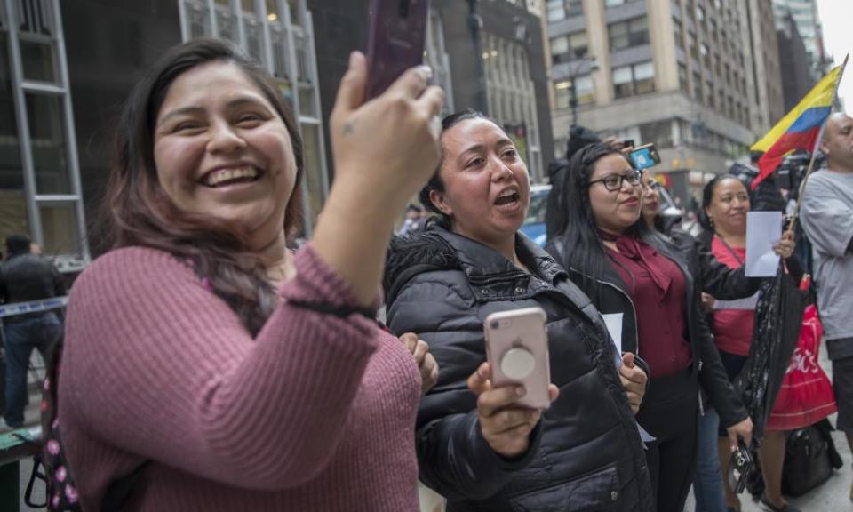 Demonstrators sing along as a mariachi band performs during a demonstration across the street from the building that once housed the office space of Aaron Schlossberg.