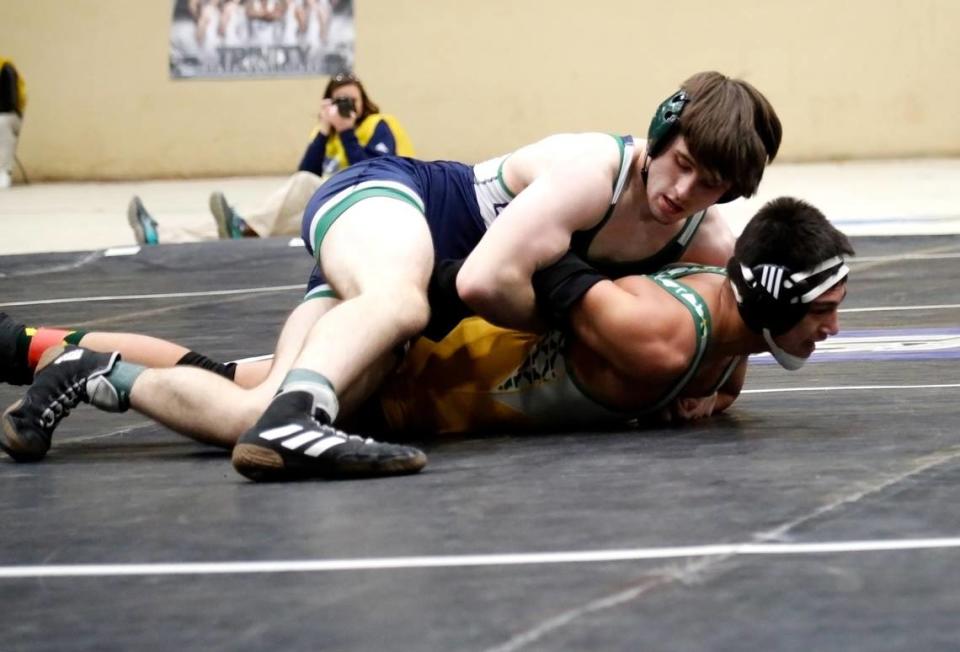 Great Crossing’s Aiden Butler holds down St. Xavier’s Max Speaker during their 165 class finals match at the boys/coed KHSAA State Wrestling Championships at the Kentucky Horse Park’s Alltech Arena on Friday, Jared Peck/jpeck@herald-leader.com