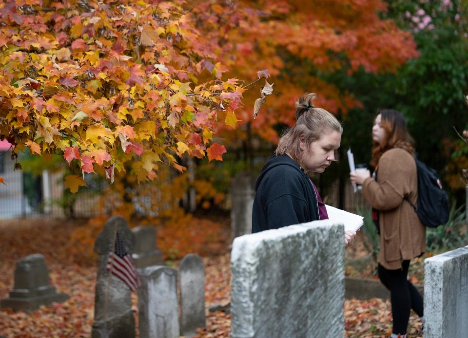 Oct 25, 2023; Westerville, Ohio, USA; Student Kam Moore considers gravestones during a Philosophy Class on a "philosophical gallery walk" at the Olde Methodist Cemetery in Westerville.