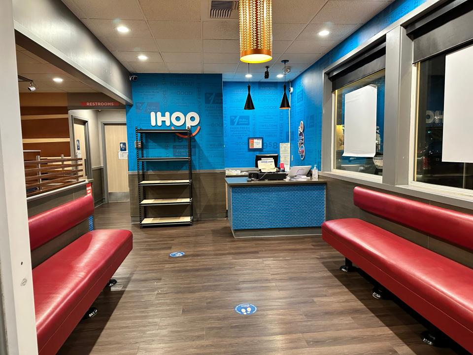 Red and blue interior at ihop, with seating benches and check-in desk