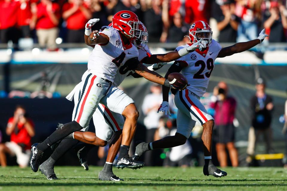 Georgia linebacker Nolan Smith celebrates his first-half interception against Florida with teammates.