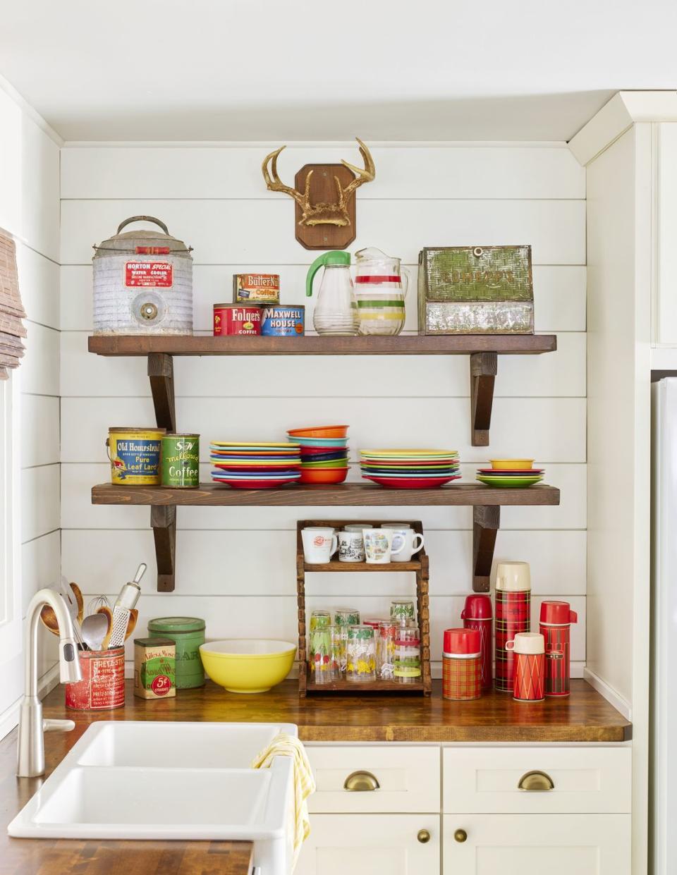 kitchen shelves filled with fiestaware and plaid thermoses