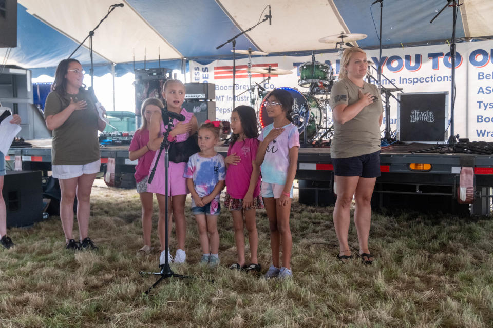 A group of young girls leads the crowd in the Pledge of Allegiance Saturday at the Homeless Heroes Bike Run event in Amarillo.