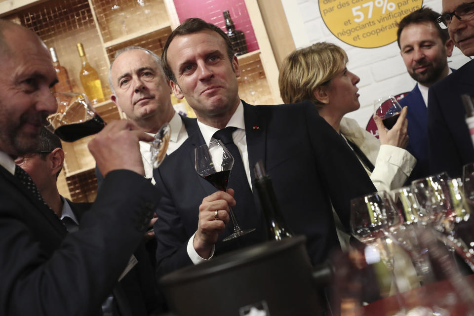 French President Emmanuel Macron drinks wine during a visit to the International Agriculture Fair (Salon de l'Agriculture) at the Porte de Versailles exhibition center in Paris, Saturday, Feb. 22, 2020. (Christophe Petit Tesson/Pool via AP)