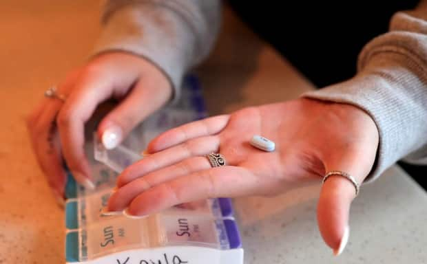 A woman holds up the medication that she takes for her cystic fibrosis in a 2019 file photo. The chief scientific officer of Cystic Fibrosis Canada calls Trikafta the 'biggest innovation in cystic fibrosis treatment.' (Cristina M. Fletes/St. Louis Post-Dispatch/TNS/Getty Images - image credit)