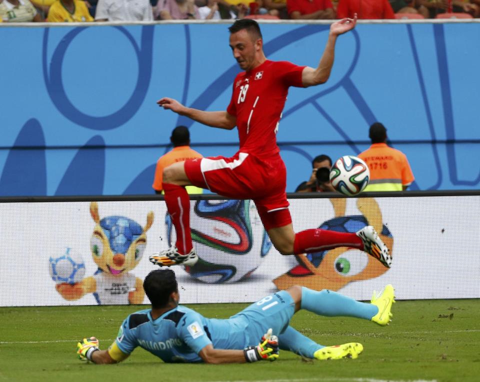 Switzerland's Josip Drmic jumps over Honduras goalkeeper Noel Valladares during their 2014 World Cup Group E soccer match at the Amazonia arena in Manaus June 25, 2014. REUTERS/Michael Dalder (BRAZIL - Tags: SOCCER SPORT WORLD CUP)