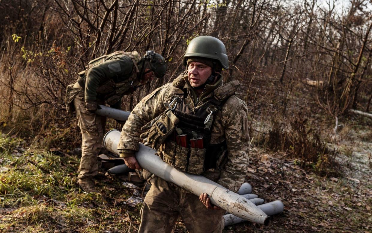 Two Ukrainian soldiers in battle dress handling missiles