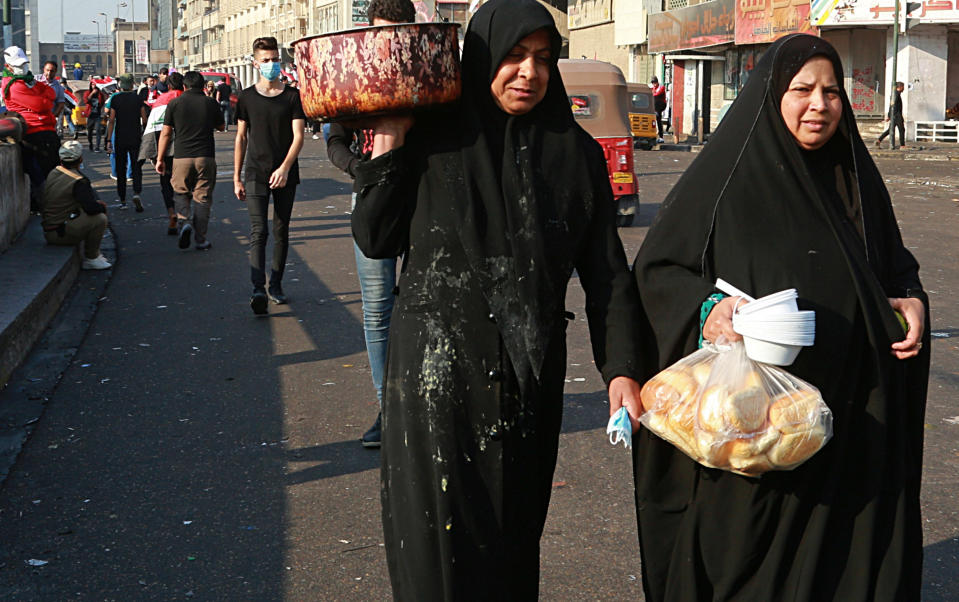 Women volunteers bring food for protesters during ongoing anti-government demonstrations, at Tahrir Square in Baghdad, Iraq, Thursday, Oct. 31, 2019. (AP Photo/Hadi Mizban)