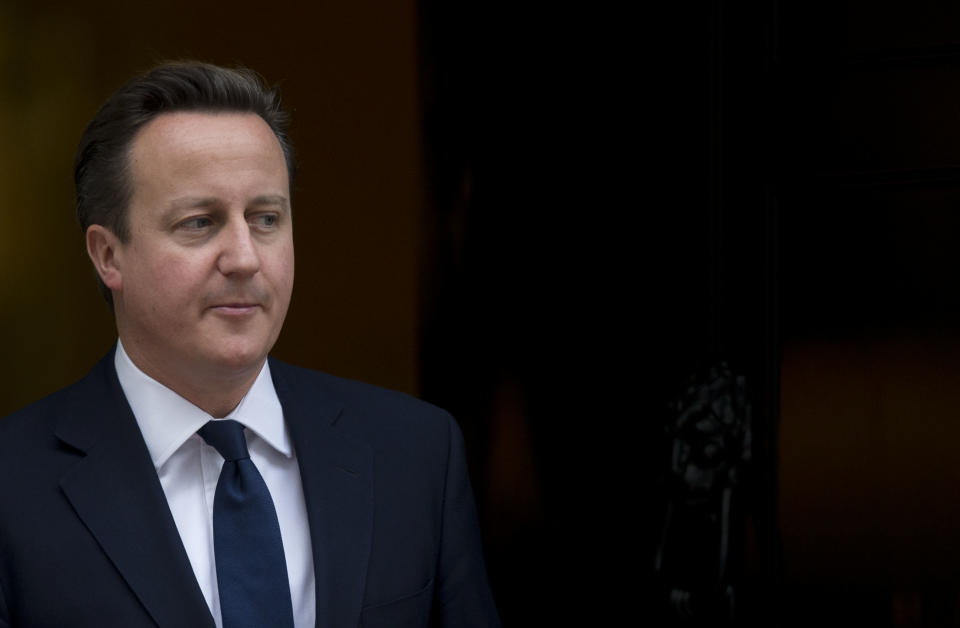 Britain's Prime Minister David Cameron walks out the front door of 10 Downing Street in London, to greet the Emir of Kuwait Sheikh Sabah al-Ahmad al-Sabah during his State Visit to the UK, Wednesday, Nov. 28, 2012. The judge who spent a year investigating the misdeeds of Britain's lively newspapers is giving Prime Minister David Cameron an early look at his recommendations for the regulation of the press. Officials say Cameron will get a copy of Lord Justice Brian Leveson's report Wednesday, a day before the public sees it, but Cameron is already being besieged with advice about how to respond to the still-secret recommendations. (AP Photo/Matt Dunham)