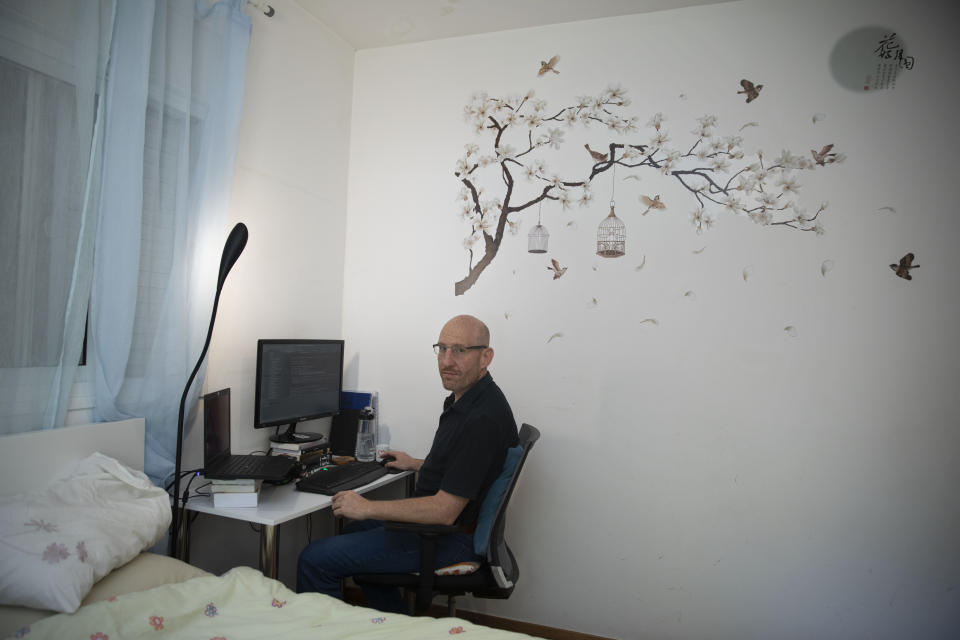 Israeli software developer Itamar Lev poses for a photograph at his house in the central Israeli city of Kfar Saba, Thursday, June 4, 2020. At first, when the coronavirus broke out, Lev was told to work from home. Then his salary was slashed 20%, his dining allowance was taken away and a long-term savings fund frozen. That's the harsh truth facing workers laid off around the world, from software companies in Israel to restaurants in Thailand and car factories in France, whose livelihoods fell victim to a virus-driven recession that's accelerating decline in struggling industries and upheaval across the global workforce. (AP Photo/Sebastian Scheiner)