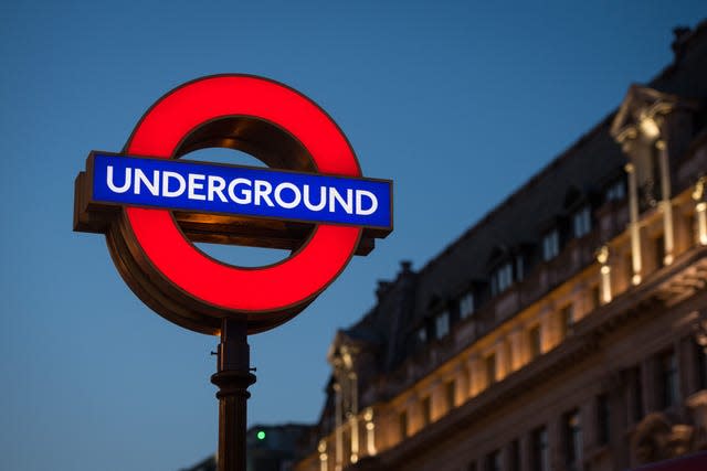 The red and blue London Underground sign, there's a slightly lit hotel in the background