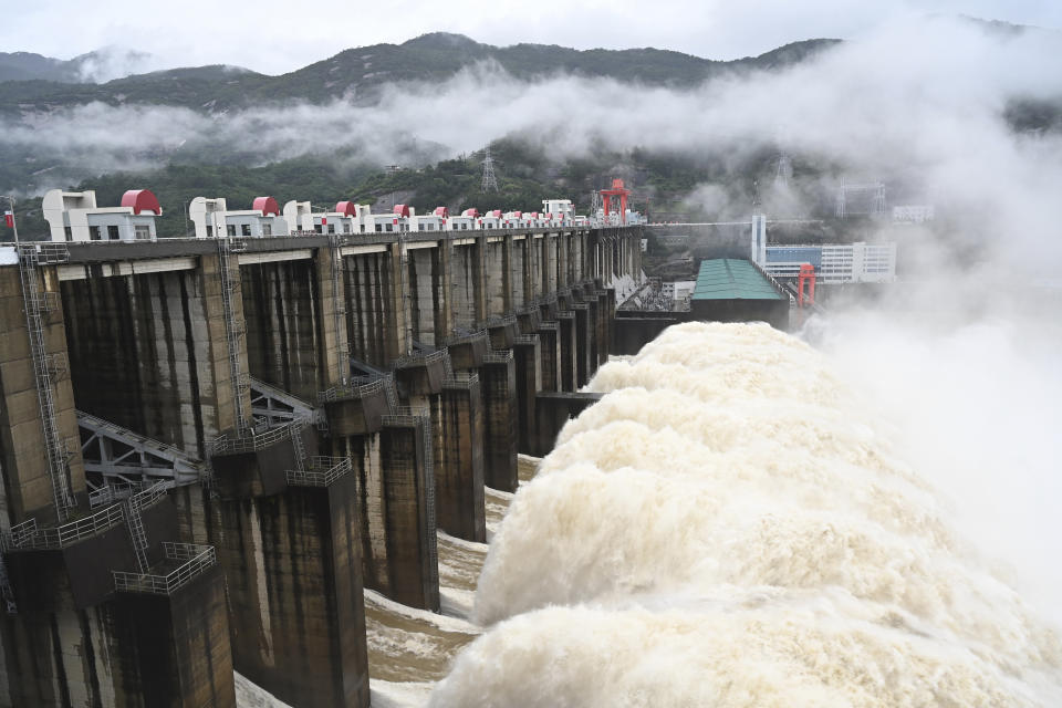 In this photo released by China's Xinhua News Agency, water flows out from a gate of the Shuikou Hydropower Station in southeastern China's Fujian Province, Monday, June 13, 2022. Heavy rain in China has claimed several lives this week and forced the evacuation of hundreds of thousands of people. (Lin Shanchuan/Xinhua via AP)