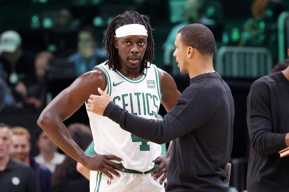 Boston Celtics head coach Joe Mazzulla, right, talks with guard Jrue Holiday during the first half of a preseason NBA basketball game against the Philadelphia 76ers, Sunday, Oct. 8, 2023, in Boston. (AP Photo/Mary Schwalm)