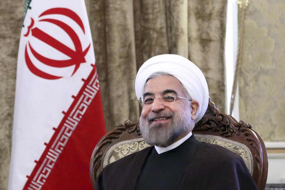 FILE - In this Sunday, Dec. 8, 2013 file photo, Iran's President Hassan Rouhani, smiles during a meeting at Tehran's Saadabad Palace in Iran. For many business leaders, Iran is a mouthwatering emerging market, and they could soon find themselves heading to Iran to secure new deals following the suspension of the first international sanctions. (AP Photo/Ebrahim Noroozi, File)