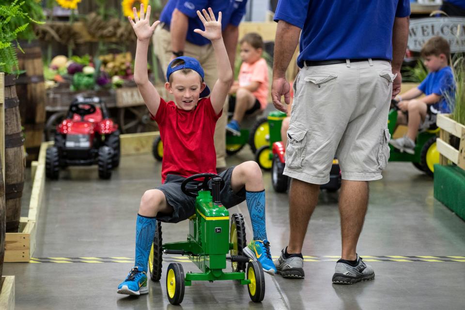 Ian Horseman, 9, of Somerset reacts as he crosses the finish line on the AgLand Pedal Tractor on the opening day at the Kentucky State Fair.  Aug. 15, 2019