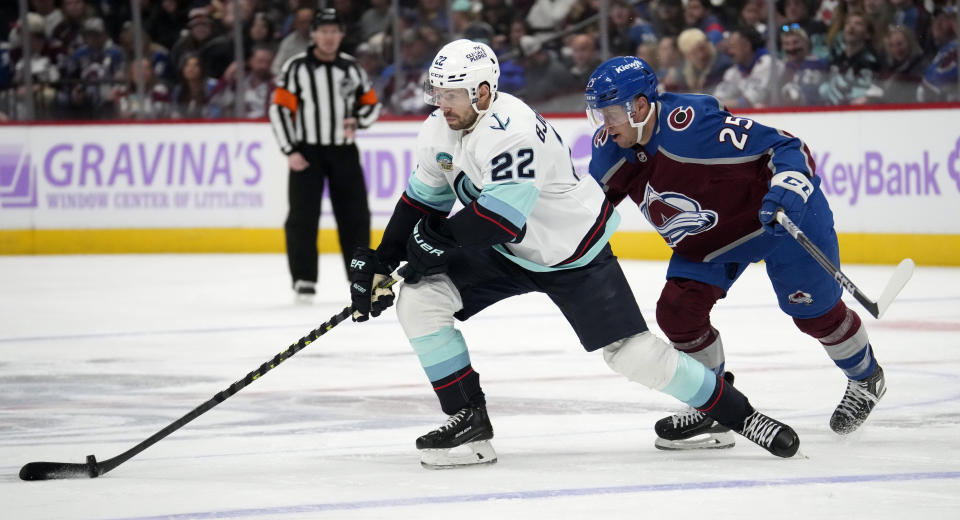 Seattle Kraken right wing Oliver Bjorkstrand, left, collects the puck as Colorado Avalanche right wing Logan O'Connor defends in the second period of an NHL hockey game Thursday, Nov. 9, 2023, in Denver. (AP Photo/David Zalubowski)