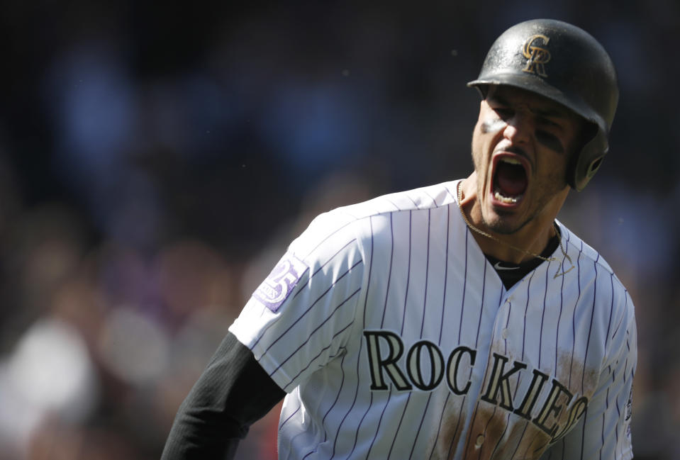 Colorado Rockies' Nolan Arenado yells as he circles the bases after hitting a two-run home run off Washington Nationals starting pitcher Erick Fedde in the first inning of a baseball game Sunday, Sept. 30, 2018, in Denver. The Rockies won 12-0. (AP Photo/David Zalubowski)