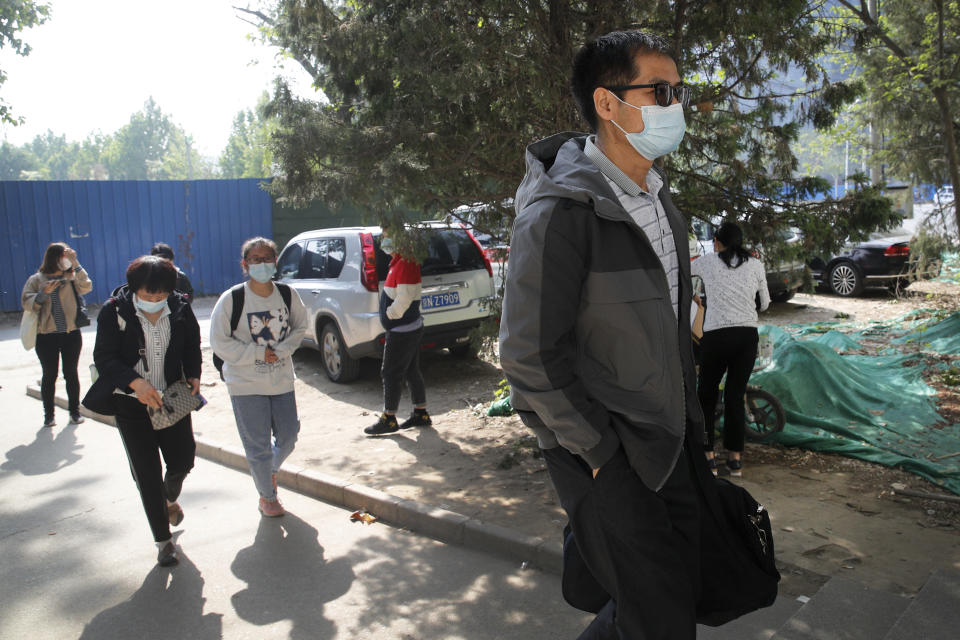 Cai Jianli, right, father of Cai Wei, is followed by Wei Xiuwen, front left, mother of Chen Mei as they arrive to a courthouse to attend their children's court cases in Beijing, Tuesday, May 11, 2021. Two amateur computer coders taken by police from their Beijing homes last year were standing trial Tuesday in a case that illustrates the Chinese government's growing online censorship and heightened sensitivity to any deviation from the official narrative on its COVID-19 response. (AP Photo/Andy Wong)