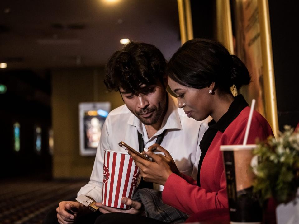 Couple waiting to get to the cinema for watching a movie with happiness