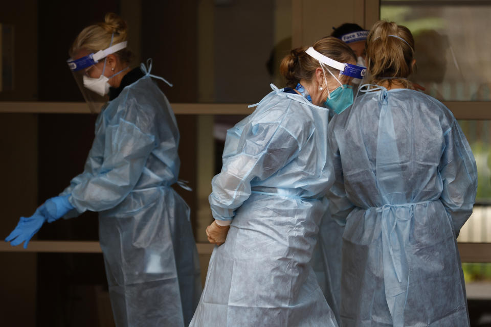 Covid testing staff put on PPE before entering the Kings Park On Southbank apartment building in Melbourne on June 15, 2021.