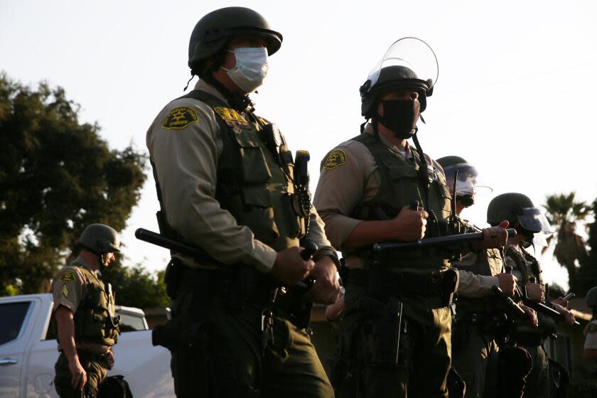 LOS ANGELES, CA - AUGUST 02: A line of sheriff's deputy's move protestors away from a picket organized by the Coalition for Community Control Over the Police at the home of Los Angeles Sheriff's deputy Miguel Vega, who fatally shot Andres Guardado in Covina on Sunday, Aug. 2, 2020 in Los Angeles, CA. (Dania Maxwell / Los Angeles Times)