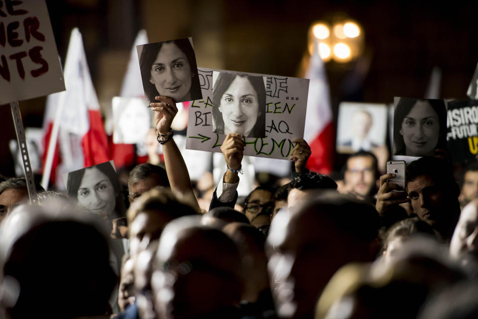 Protesters hold photos during a protest outside the office of the Prime Minster of Malta by civil groups Occupy Justice and Republica Friday, Nov. 29, 2019 in Valletta, calling for the resignation of Malta Prime Minister Joseph Muscat after his chief of staff Keith Scembri was arrested and questioned regarding the murder of slain journalist Daphne Caruana Galizia. Muscat said Friday that police found no grounds to hold Keith Schembri, his former chief of staff in custody. (AP Photo/Rene Rossignaud)