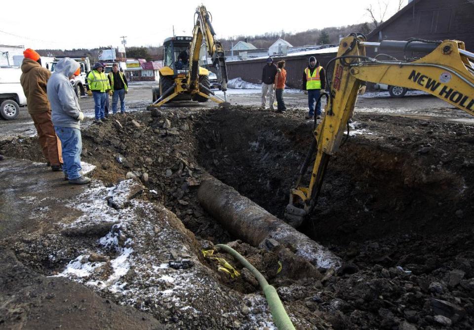 FILE- In this Jan. 19, 2016 file photo, crews work to repair a broken water main on Tuesday, Jan. 19, 2016, in Troy, N.Y. New York Gov. Andrew Cuomo has a plan to spend $2 billion to address water contamination and the state's aging, leaky pipes. (AP Photo/Mike Groll, File)