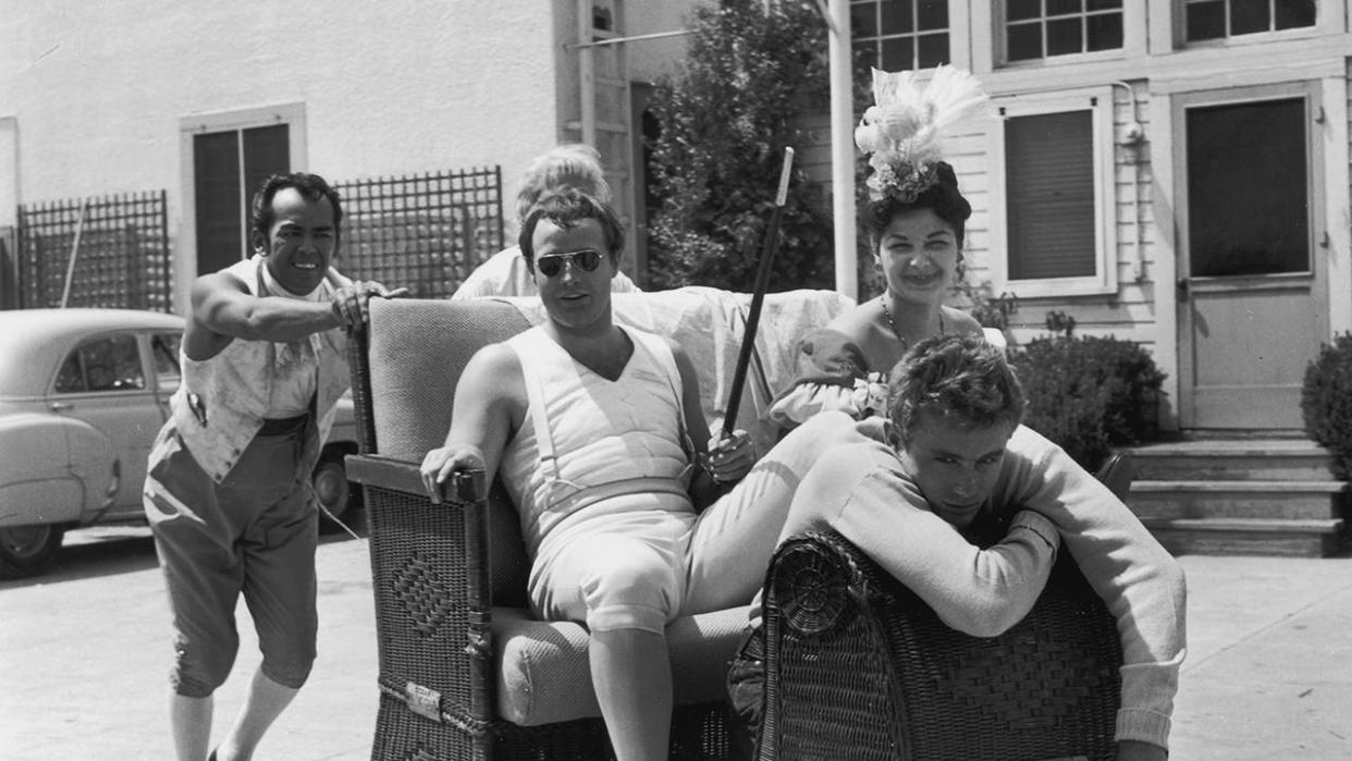 A group of people, including Marlon Brando and James Dean, posing together for a photo