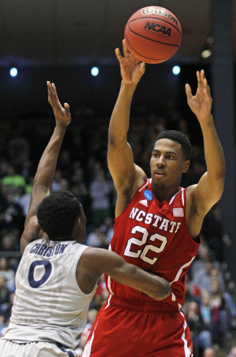 North Carolina State guard Ralston Turner (22) passes over Xavier guard Semaj Christon during the first half of a first-round game of the NCAA college basketball tournament, Tuesday, March 18, 2014, in Dayton, Ohio. (AP Photo/Skip Peterson)