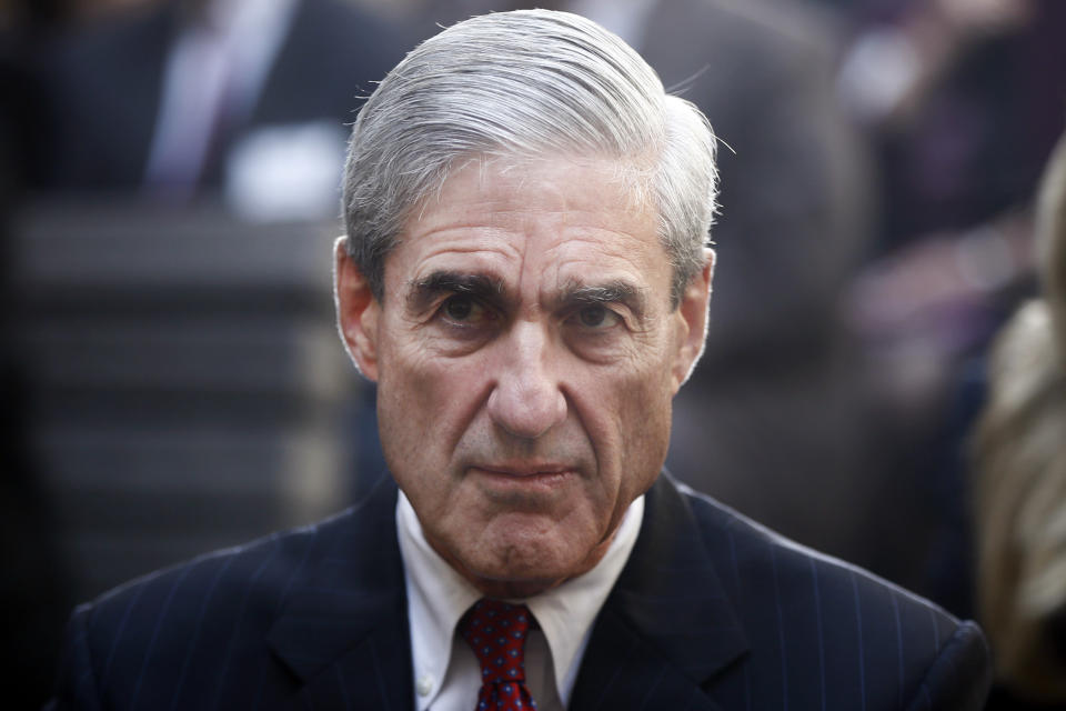 FILE – In this Oct. 28, 2013, file photo, former FBI Director Robert Mueller is seated before President Barack Obama and FBI Director James Comey arrive at an installation ceremony at FBI Headquarters in Washington. (AP Photo/Charles Dharapak, File)