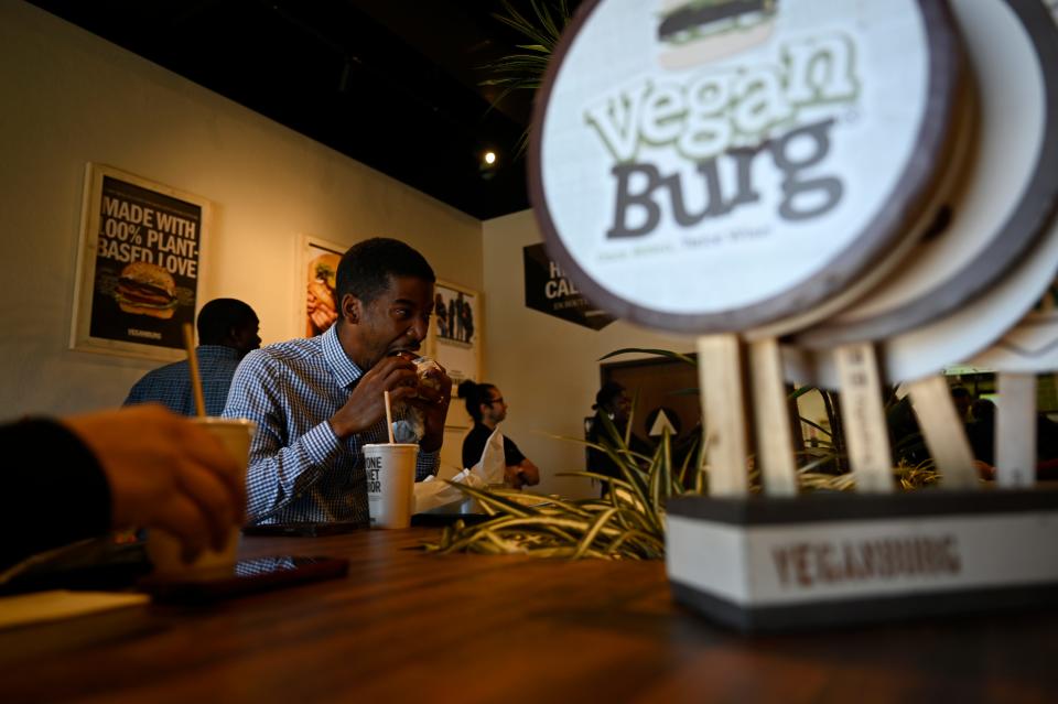Brison Robinson of Hesperia enjoys a first bite of a burger from Veganburg during the soft opening on Monday, April 15, 2024 in Hesperia.