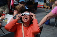 <p>People share glasses to watch the total solar eclipse in Times Square, New York City, on Aug. 21, 2017. (Gordon Donovan/Yahoo News) </p>