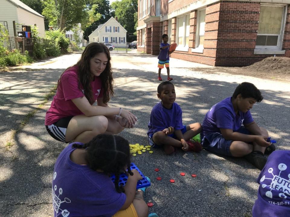 Camp Taunton counselor Kelly Simmons plays a game with a group of children outside Hopewell Elementary School.